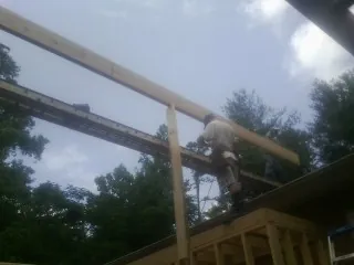 Carpenter setting a ridge beam over a new addition frame — Ice Dam Removal by Roofing Brothers in Lincoln